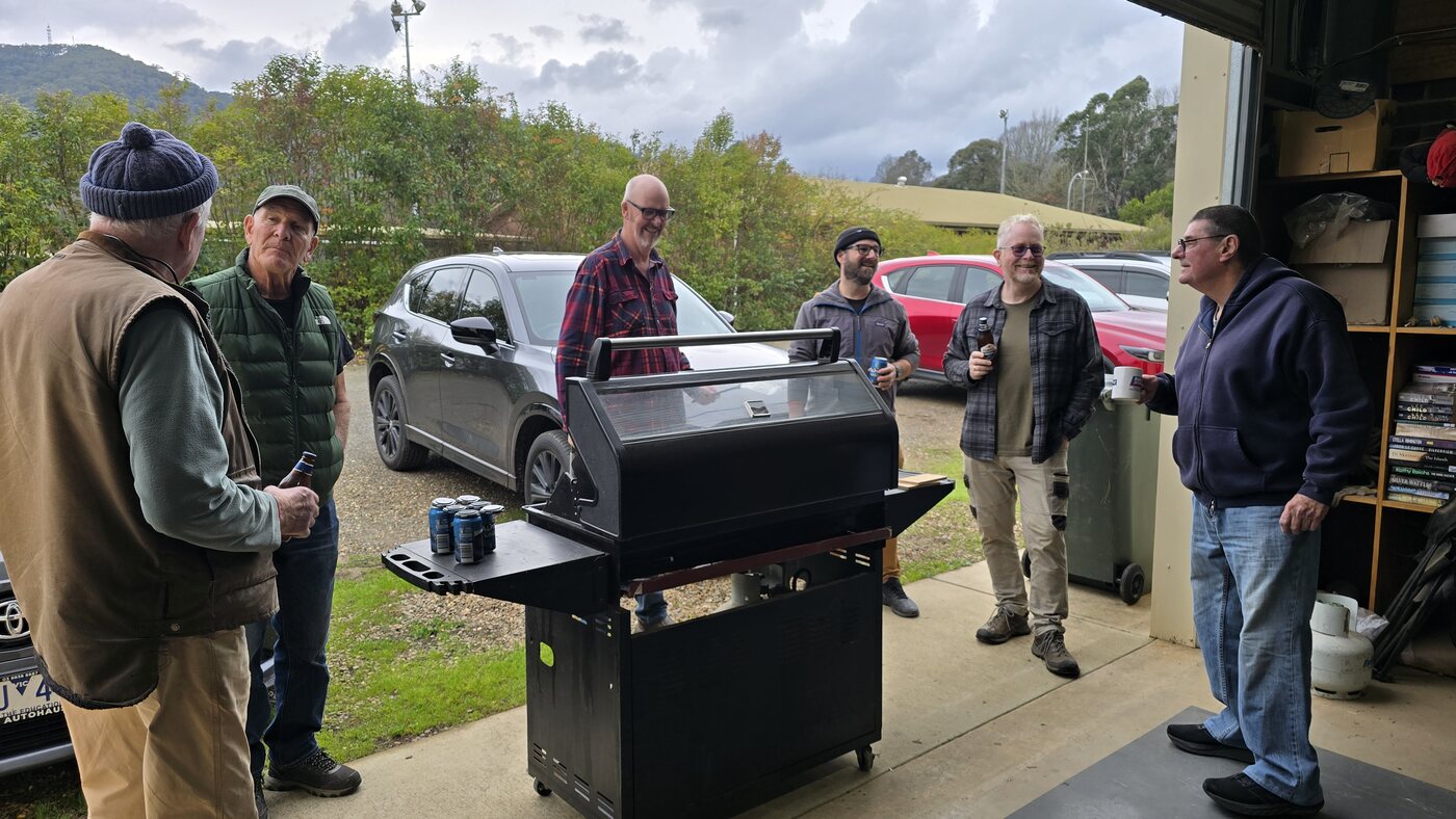 Members gathered around the barbecue outside the Bright United Men's Shed