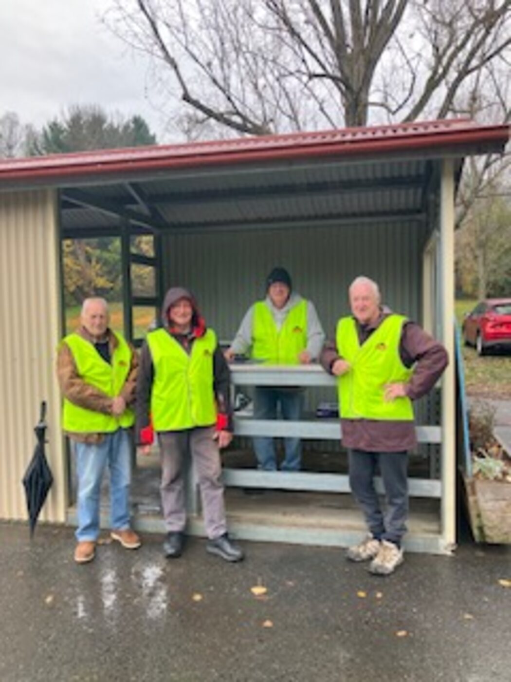 Four BUMS volunteers in hi-vis at the footy ground gate